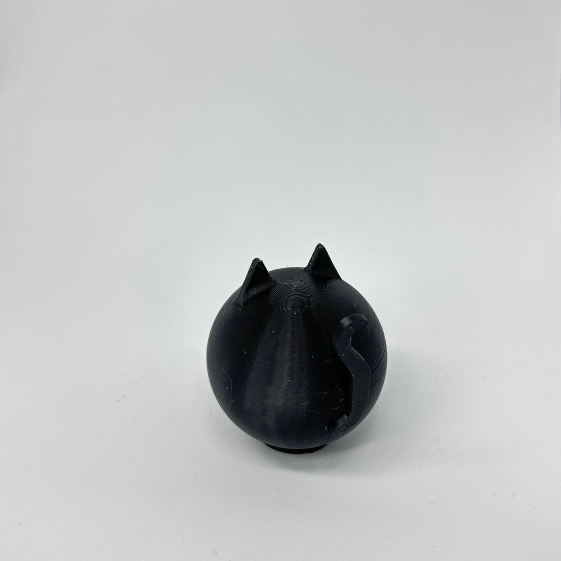 Black cat-shaped object on a white background